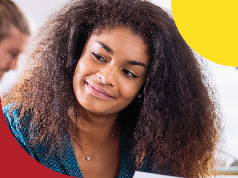 woman smiling at desk reading